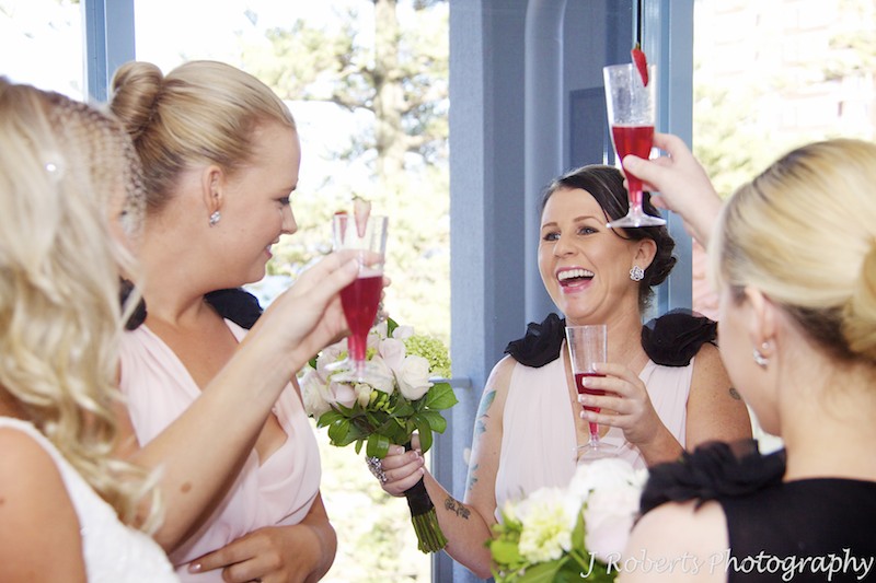 Bridesmaid cheers with champagne - wedding photography sydney